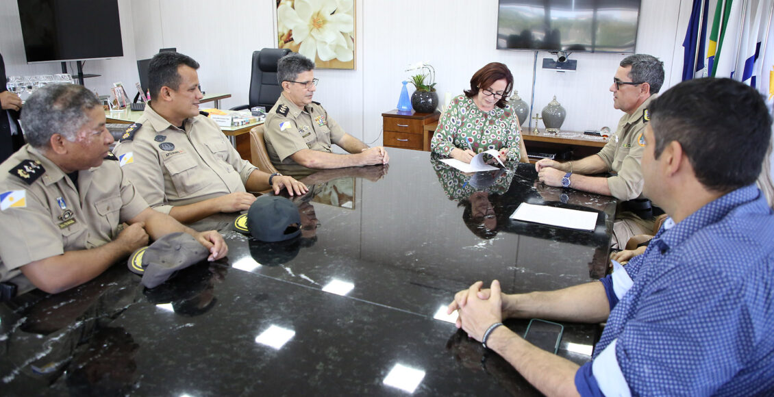 Desembargadora Etelvina Maria Sampaio Felipe oficializa doação ao assinar documento junto ao comandante da PM, coronel Barbosa, e demais membros da corporação.