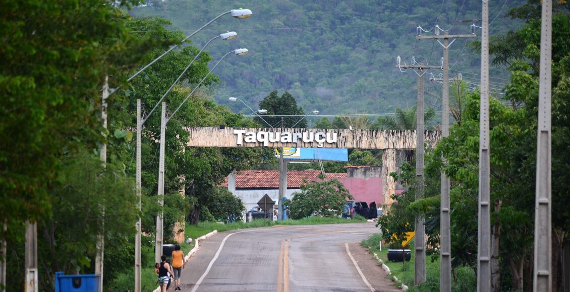 A imagem retrata a celebração em Taquaruçu como forma de agradecimento pelo apoio fundamental na construção da cidade de Palmas. Durante o evento, a comunidade é homenageada pela contribuição e dedicação à criação da capital do Tocantins. A cena mostra moradores locais reunidos, celebrando e compartilhando esse momento especial de reconhecimento.