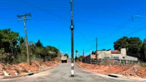 Poste de energia no meio da rua e caçamba em movimento