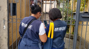 Duas supervisoras do IBGE na frente da casa de um morador na rua